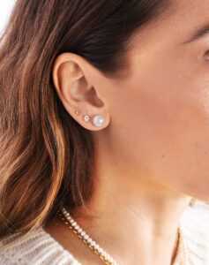 Oreille féminine avec puces en perle, diamant et or