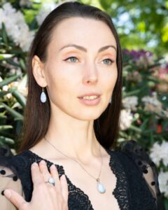 Femme portant des bijoux en pierre bleue parmi des fleurs