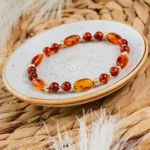Bracelet en perles d’ambre sur une assiette artisanale