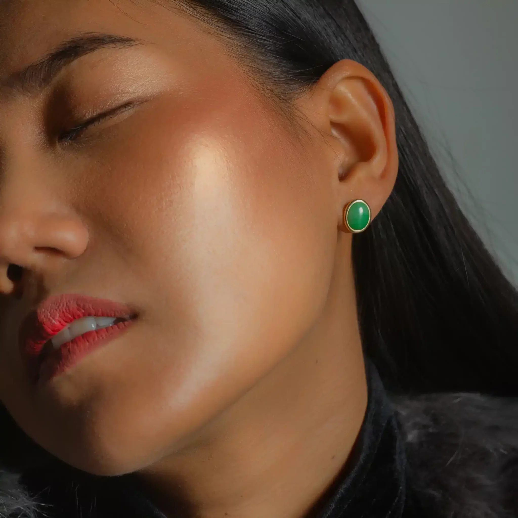 boucle-or-jade-Ivy3-scaled-1.webp Gros plan d’une femme portant une boucle d’oreille verte