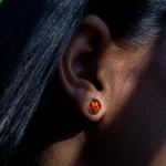 Gros plan d’une oreille portant une boucle d’oreille orange