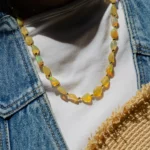 Collier de perles opalescentes sur t-shirt blanc et veste en jean