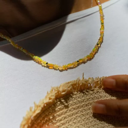 Collier de perles dorées porté sur un haut blanc