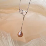 Collier argenté à cœurs entrelacés et perle rose