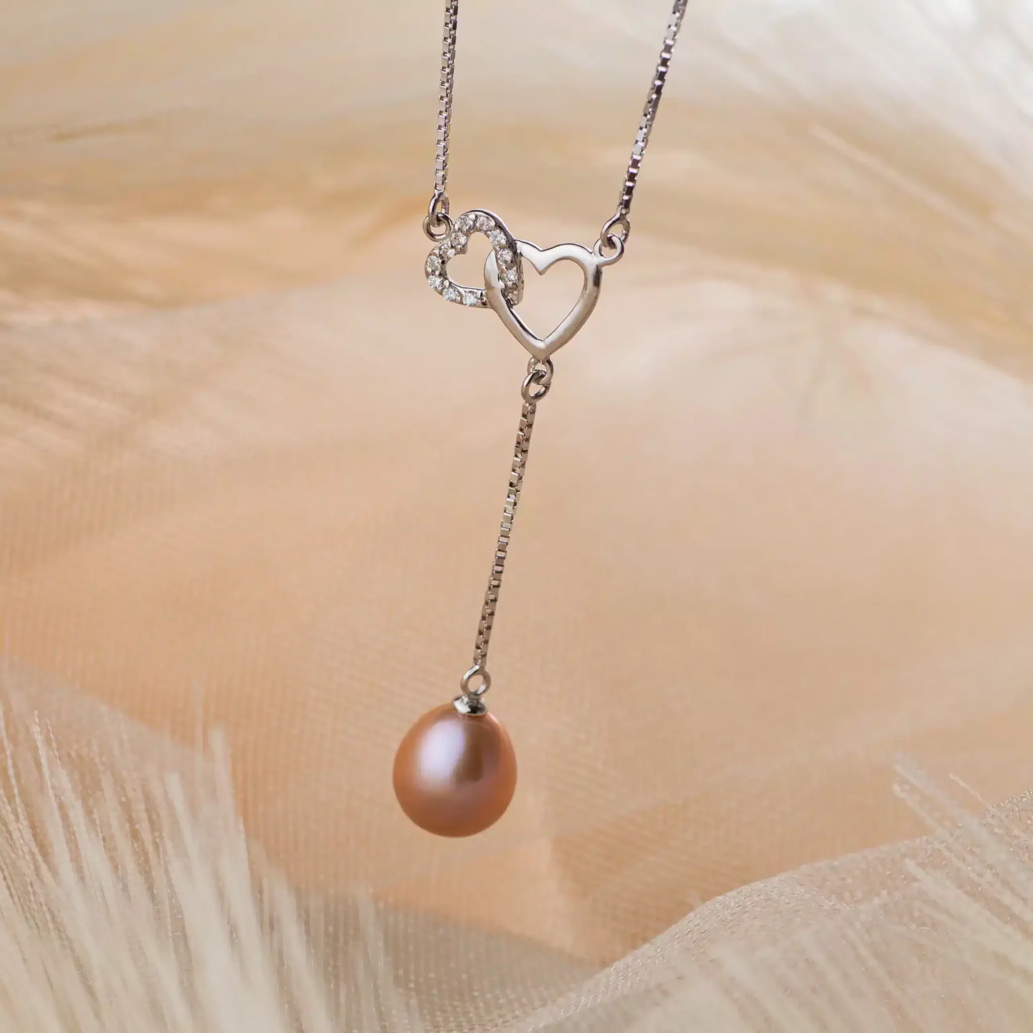 collier-perles-Heartly2-1-scaled-1.webp Collier argenté à cœurs entrelacés et perle rose