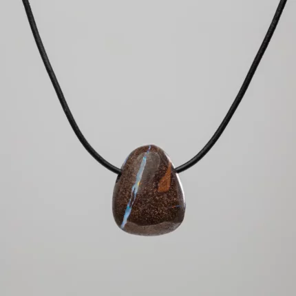Pendentif en pierre sombre avec veine bleue sur cordon noir