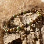 Bracelet en perles vertes et brunes sur bois
