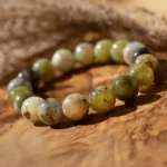 Bracelet en perles vertes et blanches sur bois