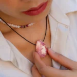 Femme portant un pendentif en pierre rose brute