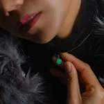 Femme portant pendentif vert sur chaîne dorée