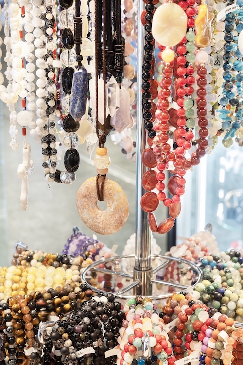 Colliers et bracelets colorés en perles exposés sur présentoir